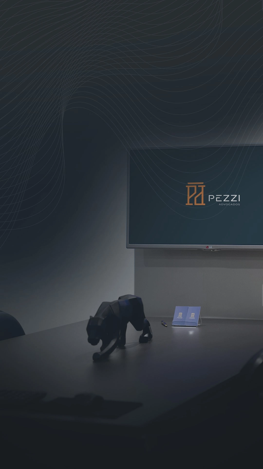 Banner com a foto da sala de reunies do Escritrio Pezzi Advogados, com uma pequena escultura decorativa de pantera sobre a mesa